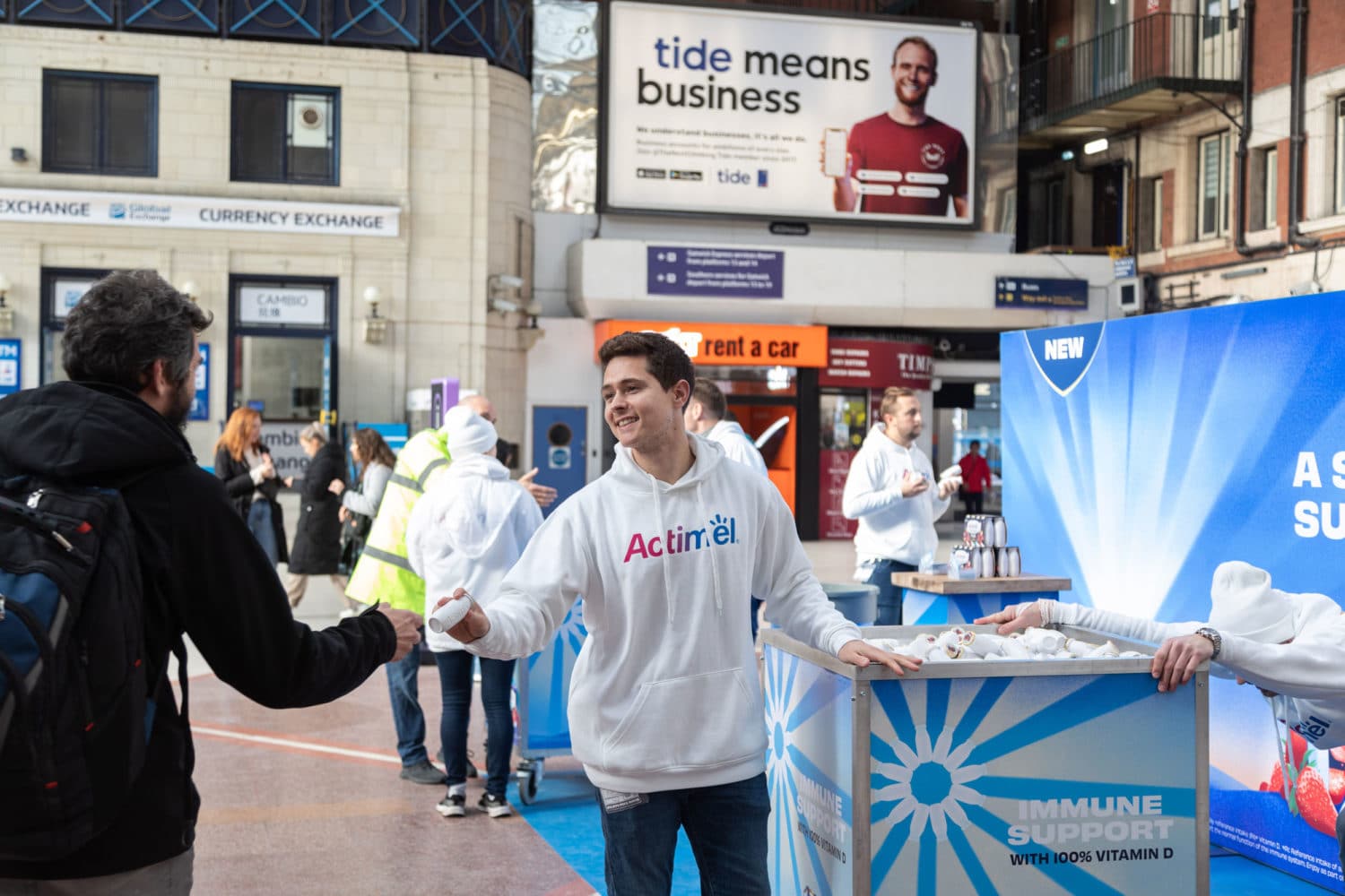 man giving drink at train station