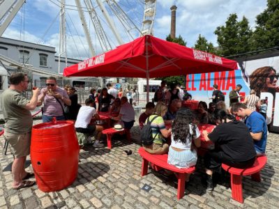 people enjoying food under red umbrella