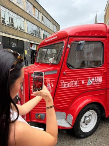 woman taking photo of red van